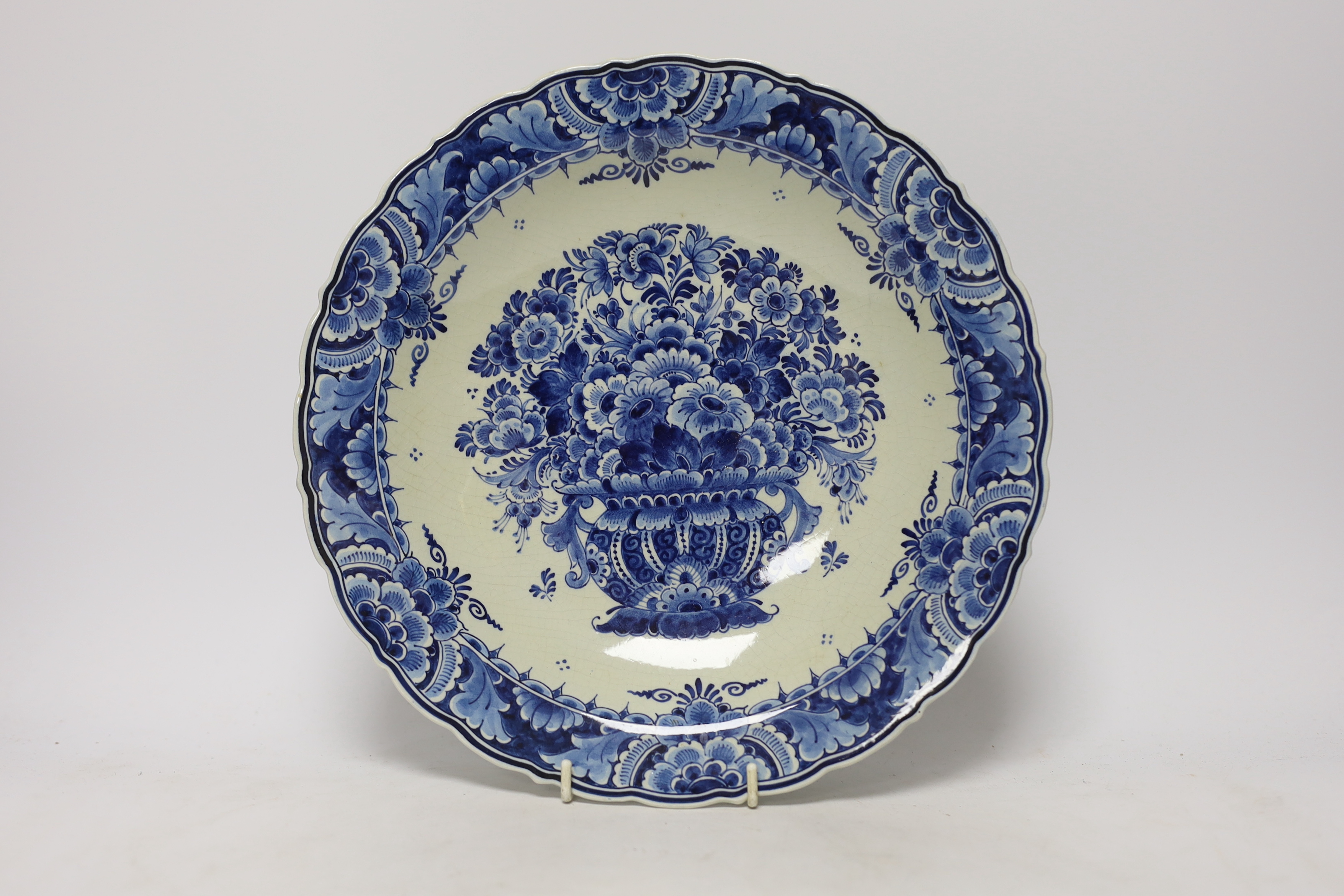 A late 18th century Delft garniture of three vases, two with covers, 32cm, together with a modern Delft plate